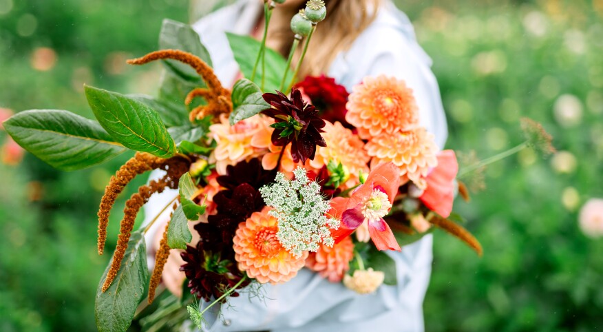 Woman holding beautiful flowers outside 