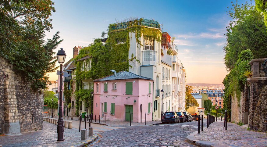 Cozy old street with pink house at the sunny sunrise, quarter Montmartre in Paris, France