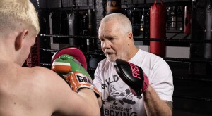Boxing trainer Freddie Roach throwing a punch at a student