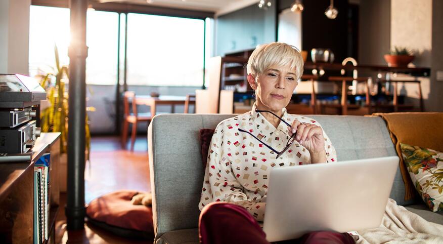 Senior woman using a laptop at home in a modern space