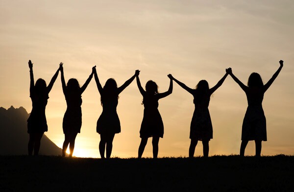 Group of women holding hands -- AARP