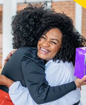 Two Black women friends exchanging gifts