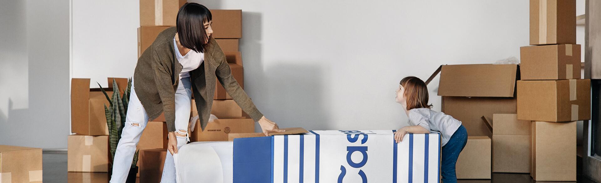 mother and daughter opening casper mattress box at home