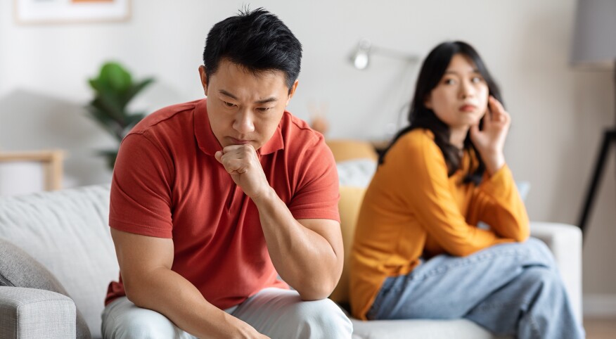 Asian couple fighting at home on the sofa