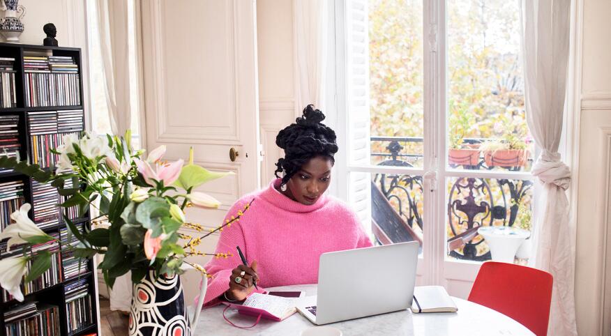 image_of_black_woman_sitting_at_table_working_on_laptop_GettyImages-1063295912_1540.jpg