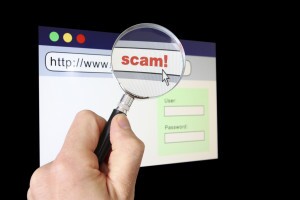 Magnifying glass over browser revealing the URL is a "scam"