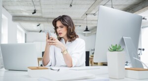 woman at work looking at her phone upset