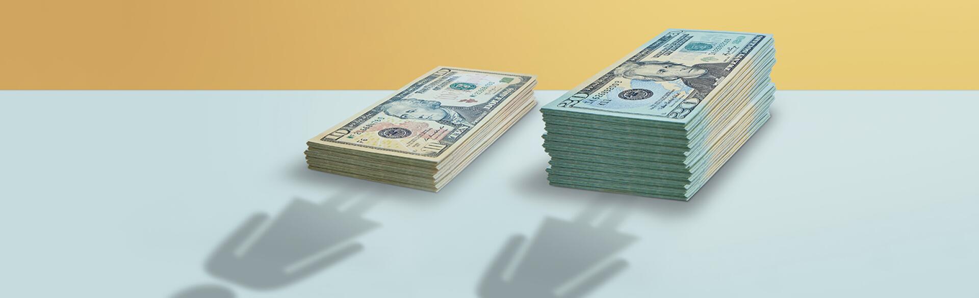 two women silhouettes by different amount stacks of money