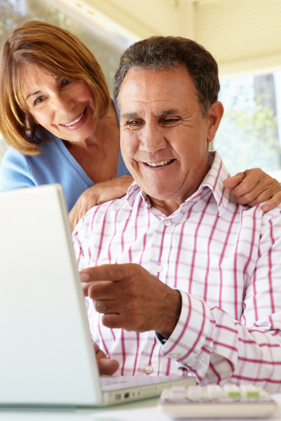 Senior Hispanic Couple Using Laptop In Home Office