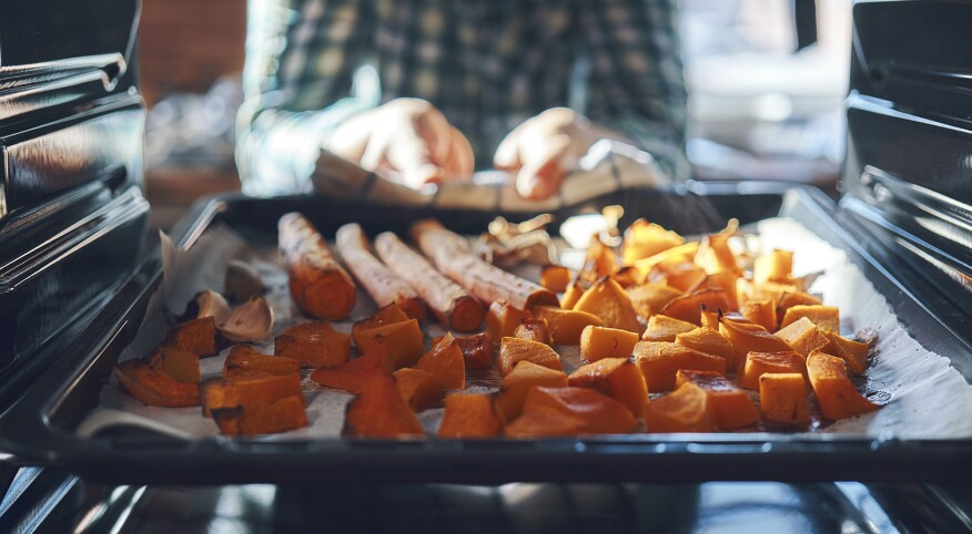 Tray of vegetables being placed in an oven