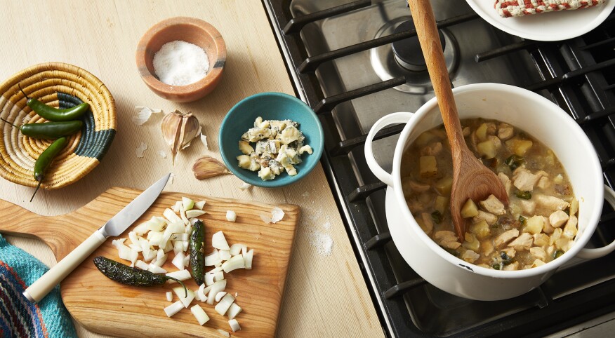 prepping and cooking chicken chili by the stove