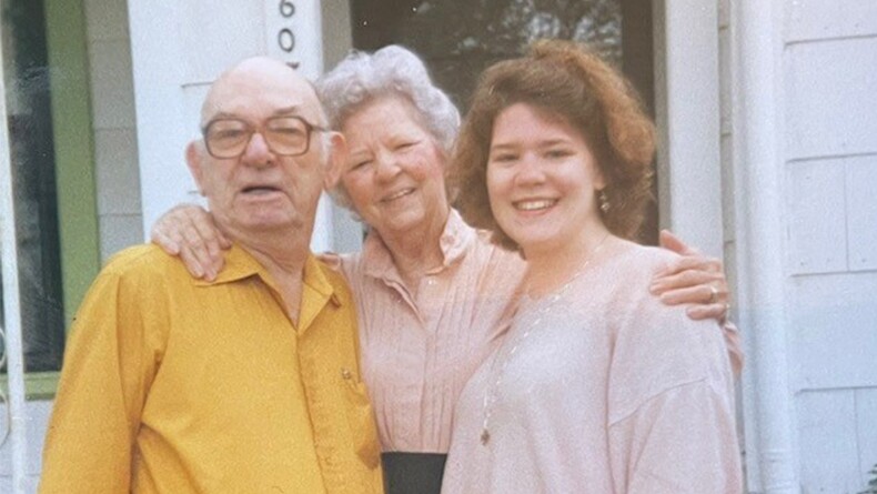 Carrie Blakeway Amero standing on front steps with her grandparents