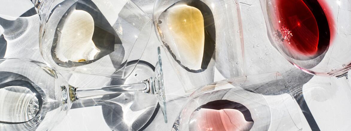 Wine Glasses on a white surface with With Different Types Of Wine inside