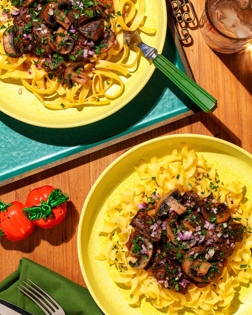 Overhead shot of two plates of beef burgundy with egg noodles