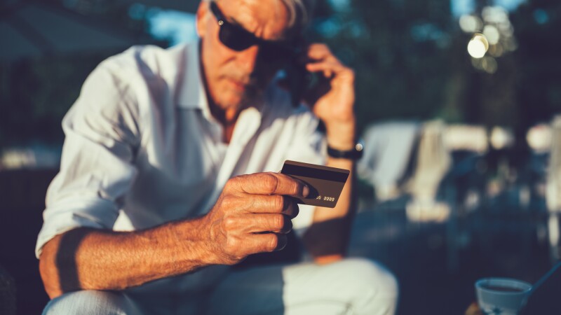 Senior man with credit card calling the bank