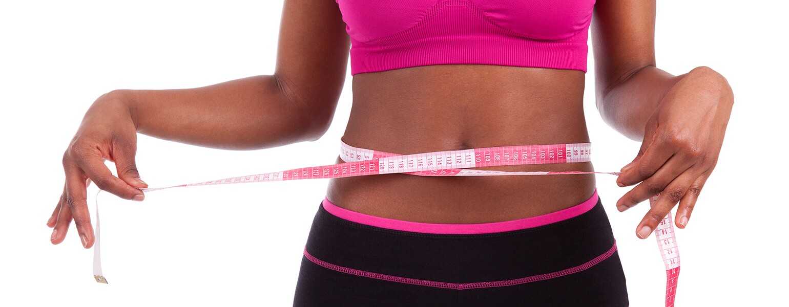 African American athlete with tape measure around stomach