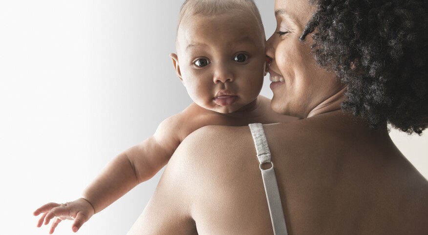 A woman holds her baby after a breast feeding session.