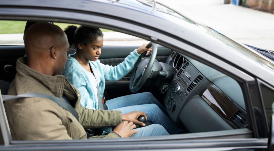 Father teaching daughter how to drive stick shift