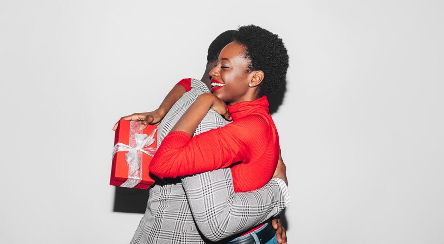 Couple embracing while holding Christmas gift