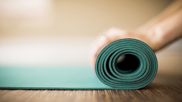 Hands rolling up a yoga mat