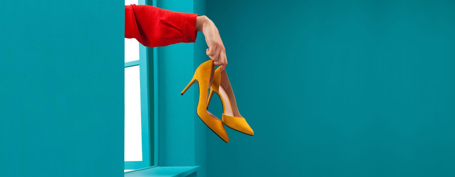 Woman throwing yellow high heels out a window