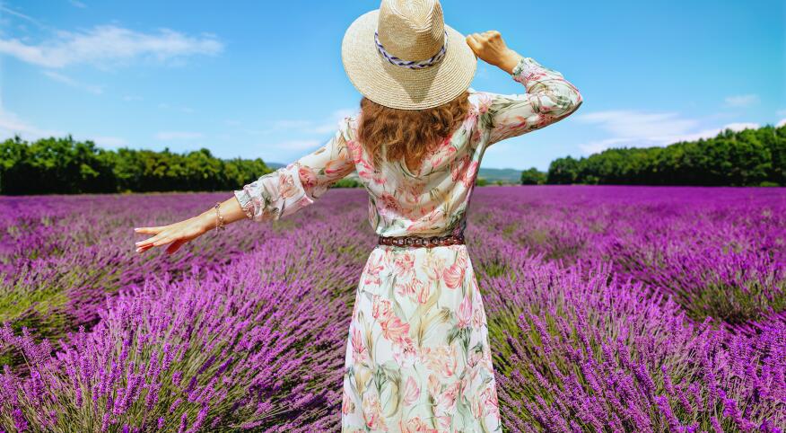 woman in sundress walking through flower field