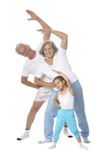 Grandparents with little girl Exercising On White Background