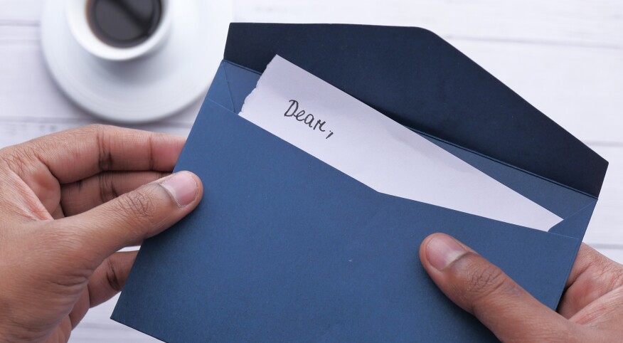 image_of_hands_opening_letter_GettyImages-1212552081_1800