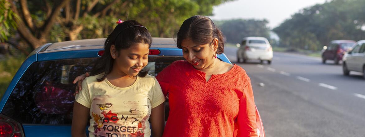 Mother And Daughter Standing Beside A Highway And Interacting