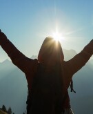 Silhouette of woman from behind enjoying the outdoors in mountains of Italy