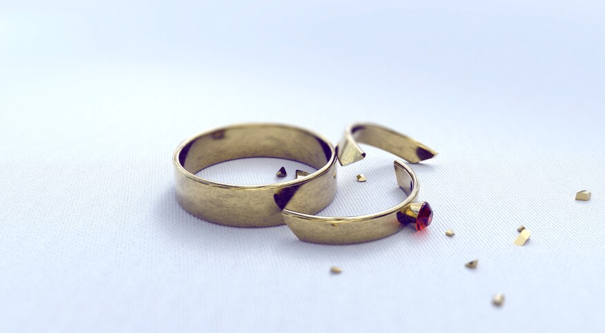 wedding band and cracked engagement ring on a white background