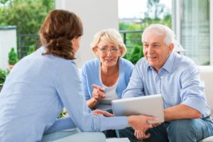 Cheerful senior couple having meeting with financial advisor or insurance agent at home