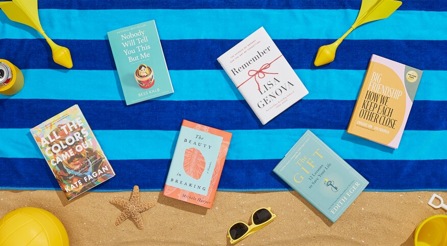 Six summer books laid out on a beach blanket