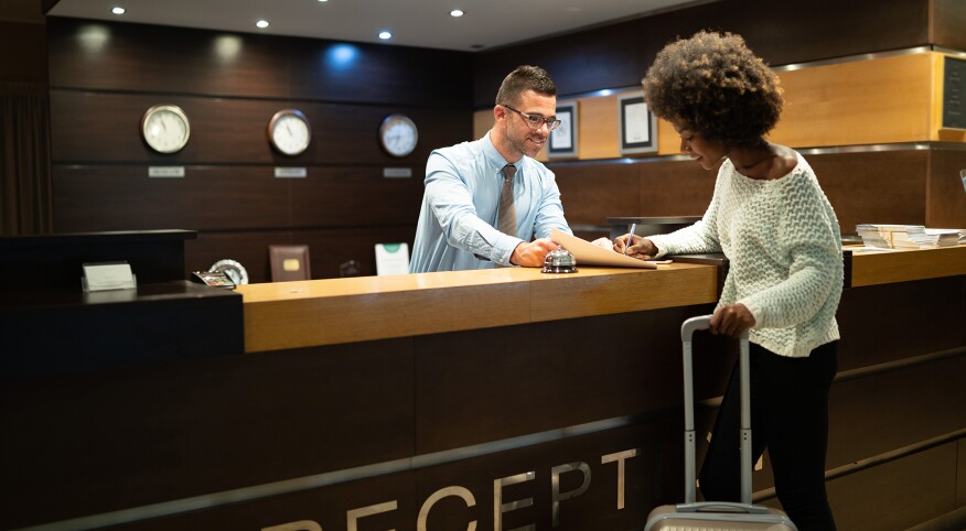 image_of_woman_checking_into_hote_GettyImages-1067309392_1800