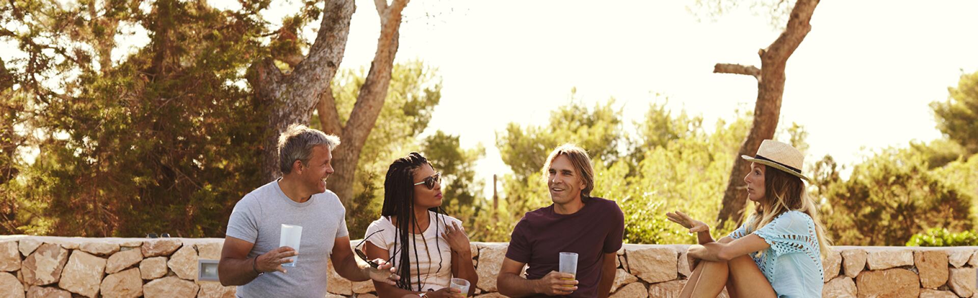 two couples sitting poolside talking hanging out together