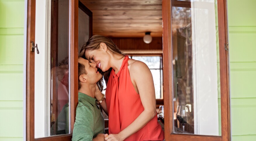 Woman and man kissing in a window sill