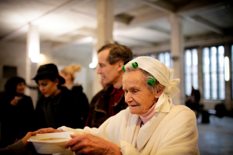 Woman eats soup at soup kitchen