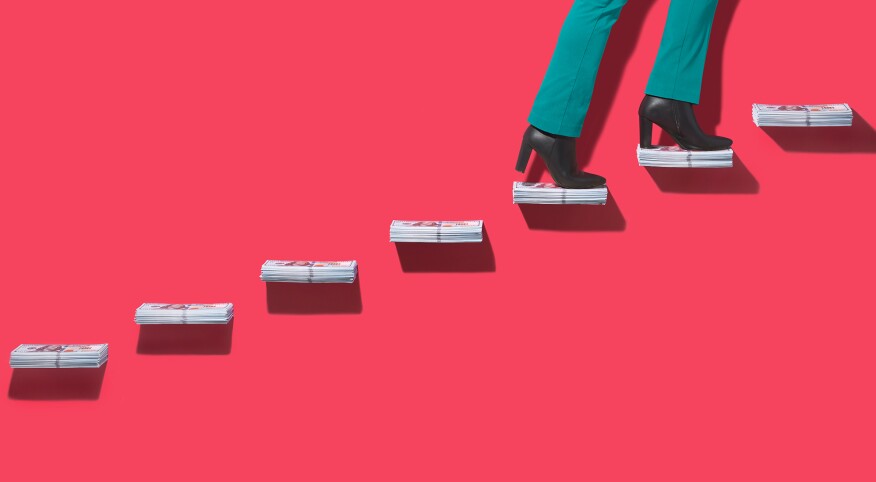 Woman walking up stairs made of dollar bill stacks