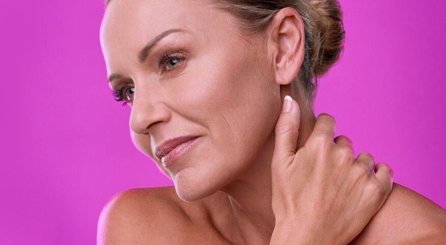 Mature woman with beautiful skin on a magenta background