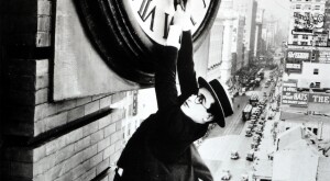 Harold Lloyd hangs on a clock outside a building