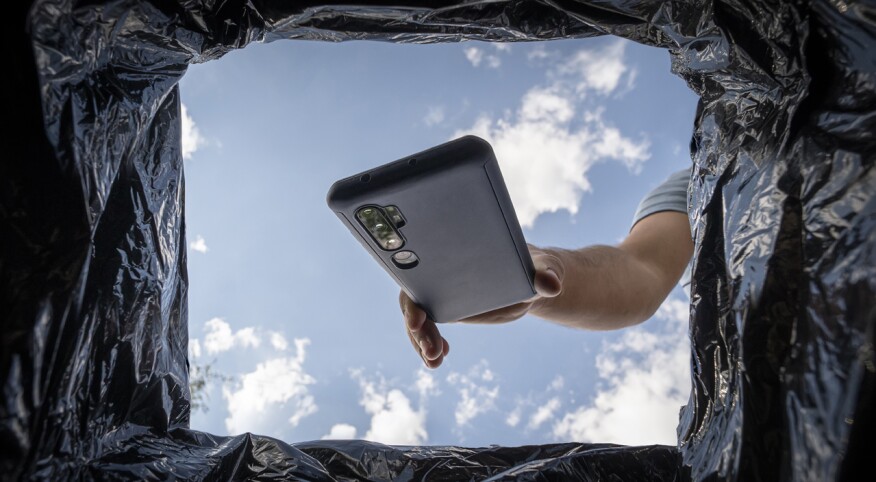 Man throwing smartphone in garbage