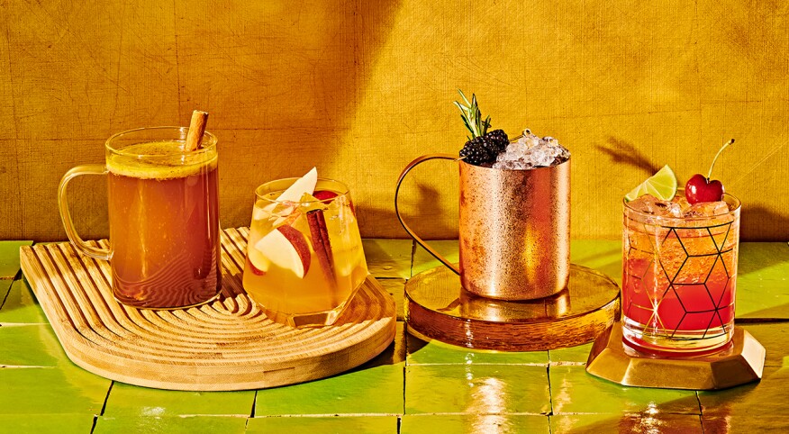 Four beautiful fall mocktails in a glowing warm light