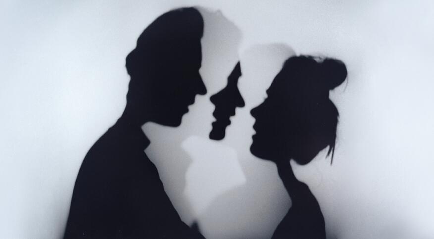 A photo of a woman and man standing face to face.