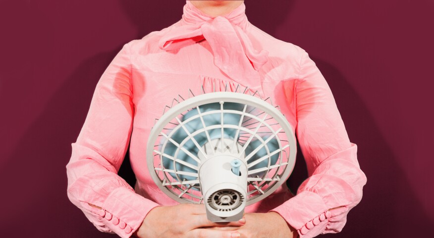 Woman holding a fan with sweat stains