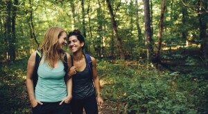 Two women best friends on a hike in the woods.