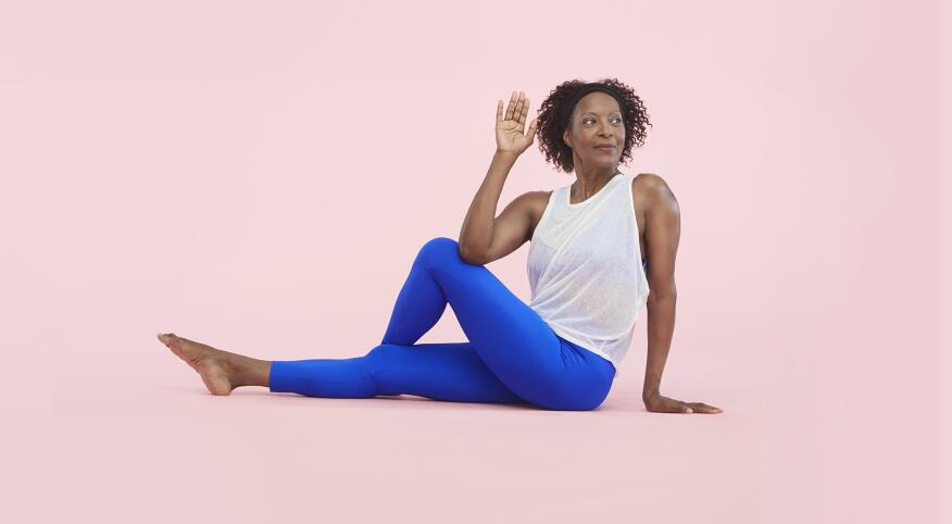 african american woman wearing athletic clothes stretching on a pink pastel background