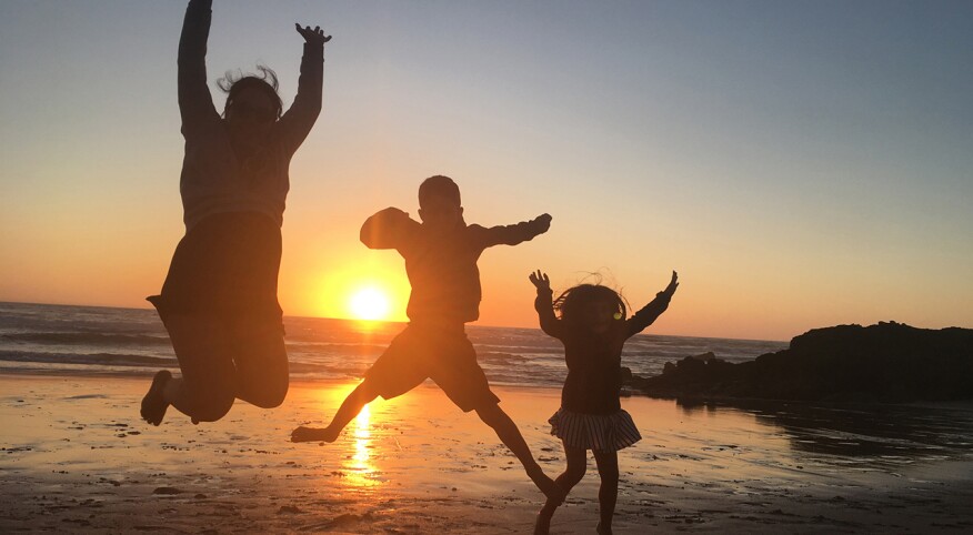 Mother and children jumping. Praia do Malhão beach, Vila Nova de Milfontes. Portugal.