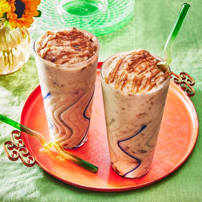 Two Date Shakes in tall glasses with green glass straws