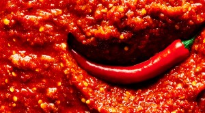 An image of a chili pepper in hot sauce.