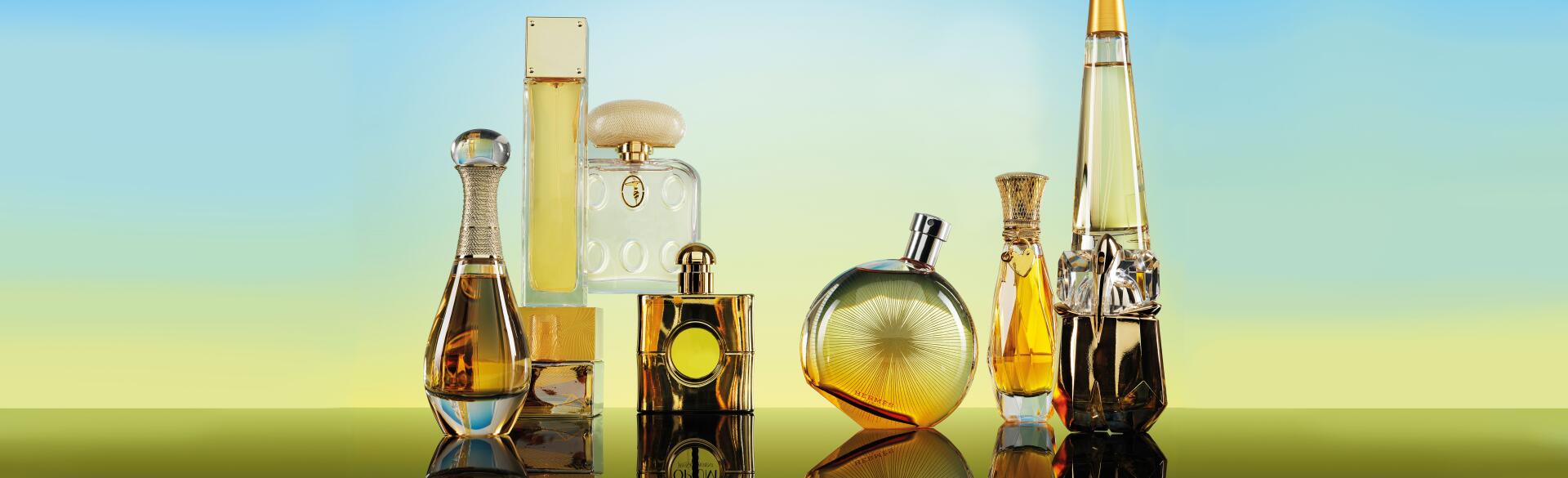 Seven Perfume bottles on a gradient blue to yellow background